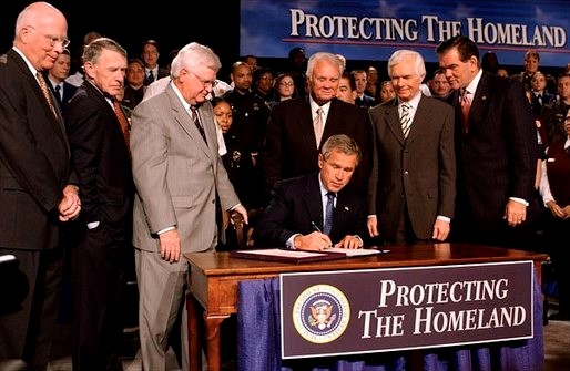 President Bush Signs Homeland Security Appropriations Bill surrounded by politicians